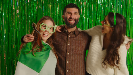 Studio-Portrait-Shot-Of-Friends-Dressing-Up-With-Irish-Novelties-And-Props-Celebrating-St-Patrick's-Day-Against-Green-Tinsel-Background-1